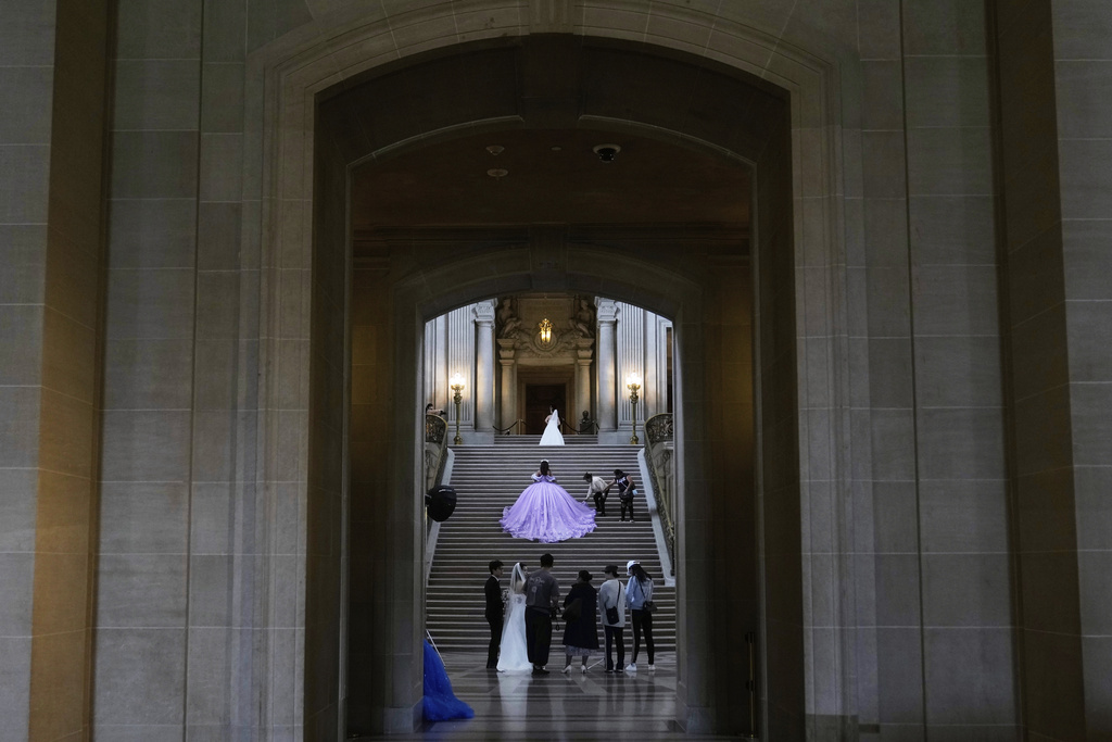 Young women in quinceañera gowns hold their profesional portrait sessions at City Hall in San Francisco, Tuesday, July 22, 2025. (AP Photo/Jeff Chiu)