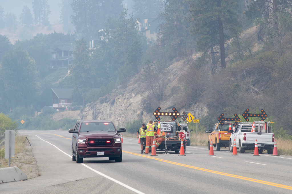 An emergency vehicle passes a closed section of Highway 97 south of Peachland, British Columbia, Canada, on Saturday, Aug. 8, 2026. (Gary Nylander/The Canadian Press via AP)