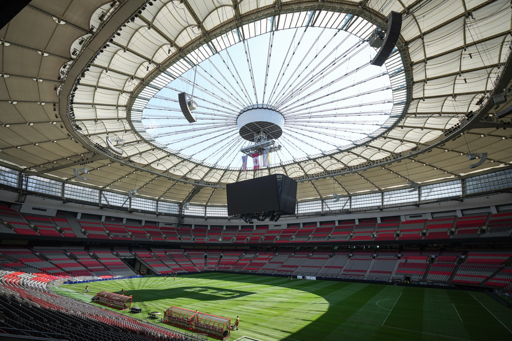 FILE - Stadium staff prepare temporary grass that was laid on top of artificial turf at BC Place stadium for a friendly soccer match between MLS soccer's Vancouver Whitecaps and League One's Wrexham, in Vancouver, on Friday, July 26, 2024. (Darryl Dyck/The Canadian Press via AP, File)