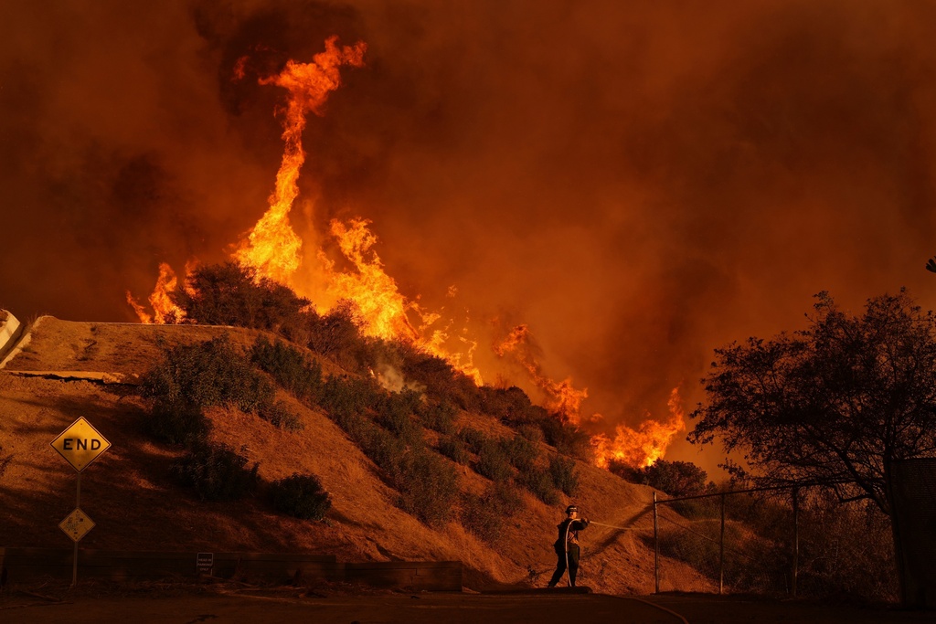 FILE - A firefighter battles the Palisades Fire in Mandeville Canyon on Jan. 11, 2025, in Los Angeles. (AP Photo/Jae C. Hong, File)