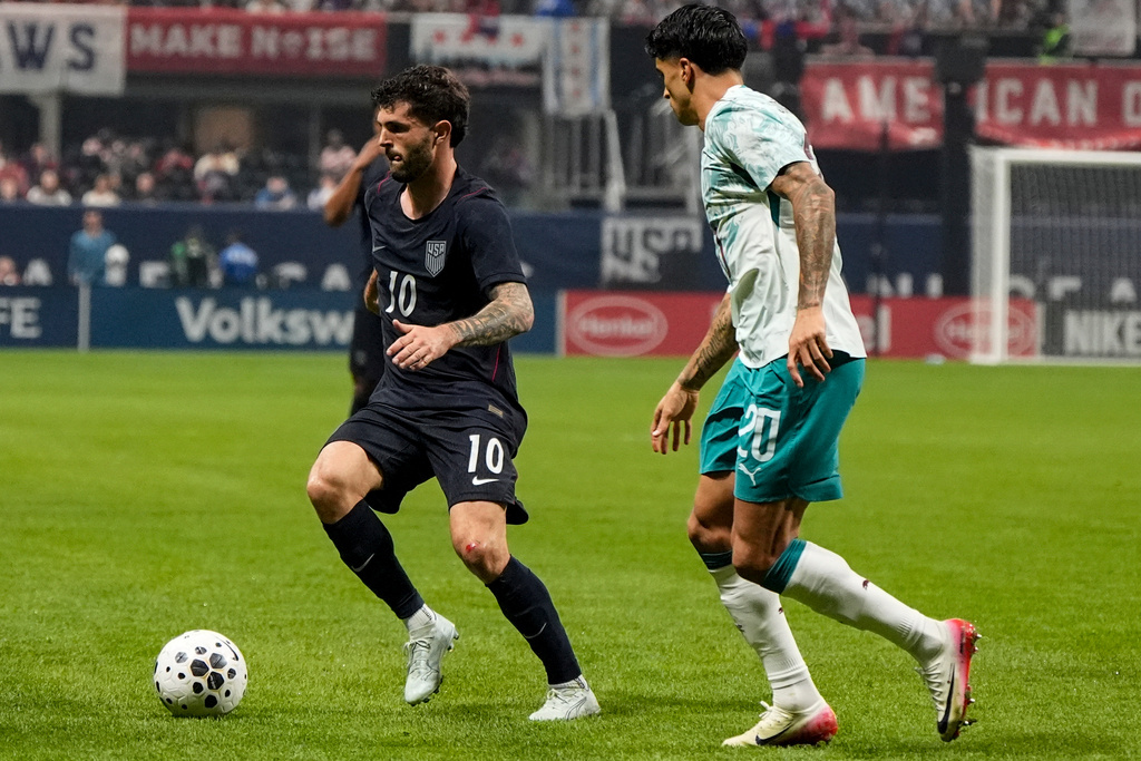 USA's Christian Pulisic (10) moves against Portugal's Joao Cancelo during the first half of an international friendly soccer match, Tuesday, March 31, 2026, in Atlanta. (AP Photo/Mike Stewart)