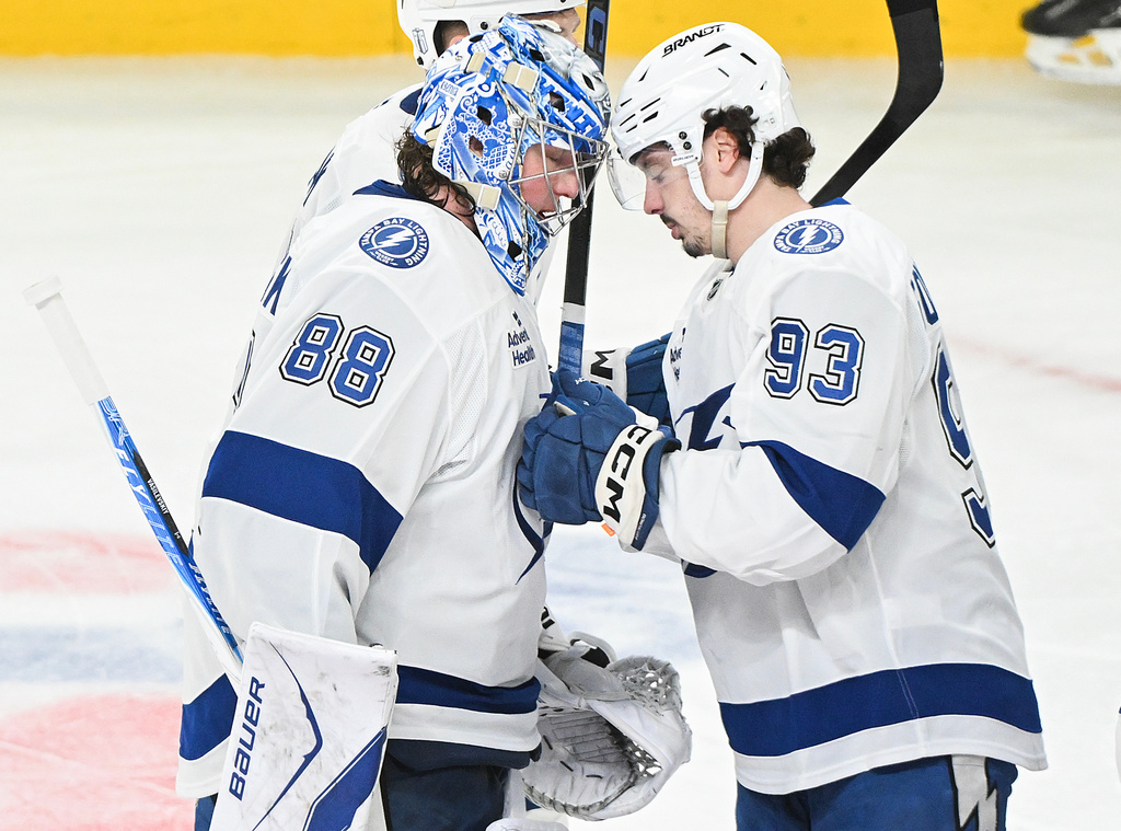 Tampa Bay Lightning's Gage Goncalves (93) celebrates with goaltender Andrei Vasilevskiy (88) following overtime of Game 6 in the first round of an NHL hockey Stanley Cup playoff series against the Montreal Canadiens in Montreal, Friday, May 1, 2026. (Graham Hughes/The Canadian Press via AP)