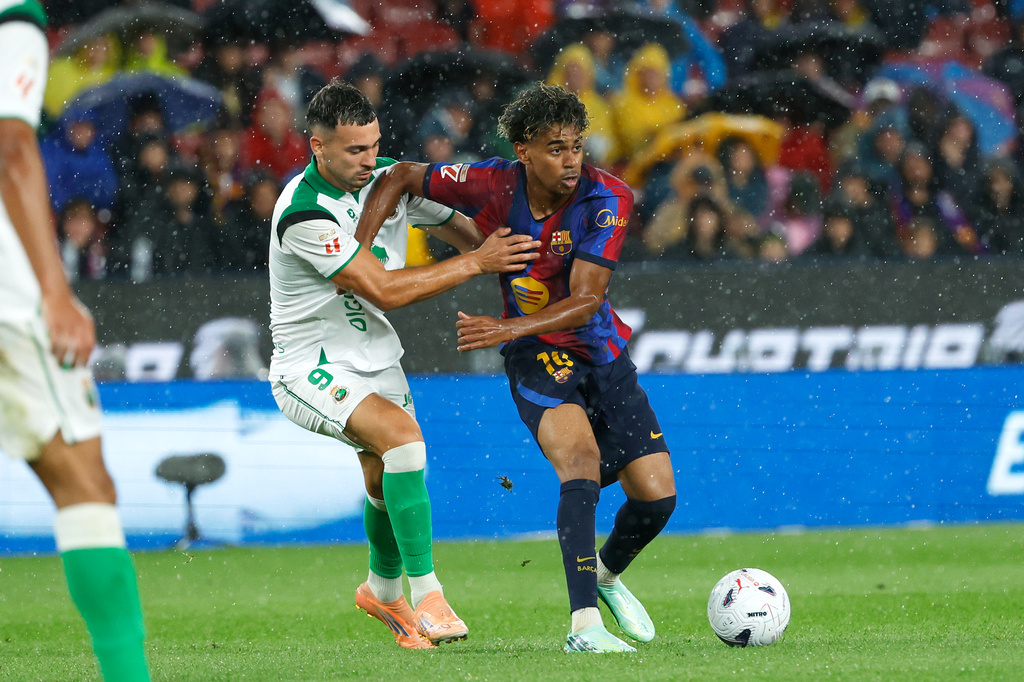 Racing's Juan Carlos Arana vies for the ball with Barcelona's Lamine Yamal, right, during a Spanish La Liga soccer match between Barcelona and Racing de Santander in Barcelona, Spain, Wednesday, Sept. 16, 2026. (AP Photo/Joan Monfort)