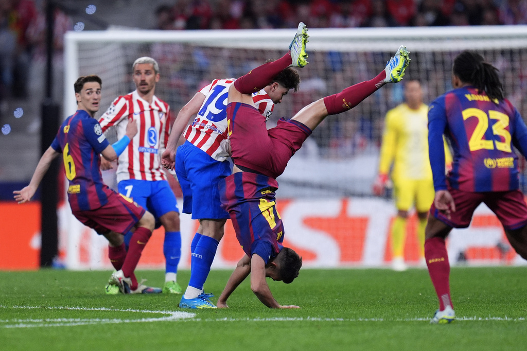 Barcelona's Eric Garcia, center right, and Atletico Madrid's Julian Alvarez challenge for the ball during the Champions League quarterfinal second leg soccer match between Atletico Madrid and Barcelona in Madrid, Spain, Tuesday, April 14, 2026. (AP Photo/Manu Fernandez)
