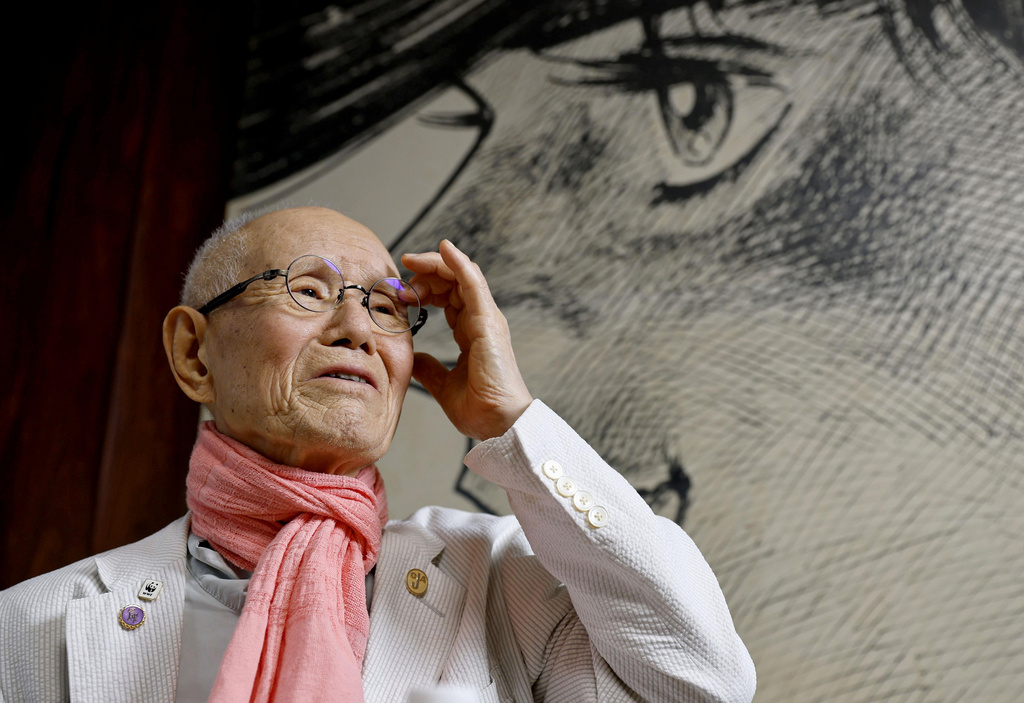 Japanese manga artist Tetsuya Chiba, poses for a photo in front of his boxing manga character in "Ashita no Joe," in Tokyo on June 18, 2026. (Masanori Kumagai/Kyodo News via AP)