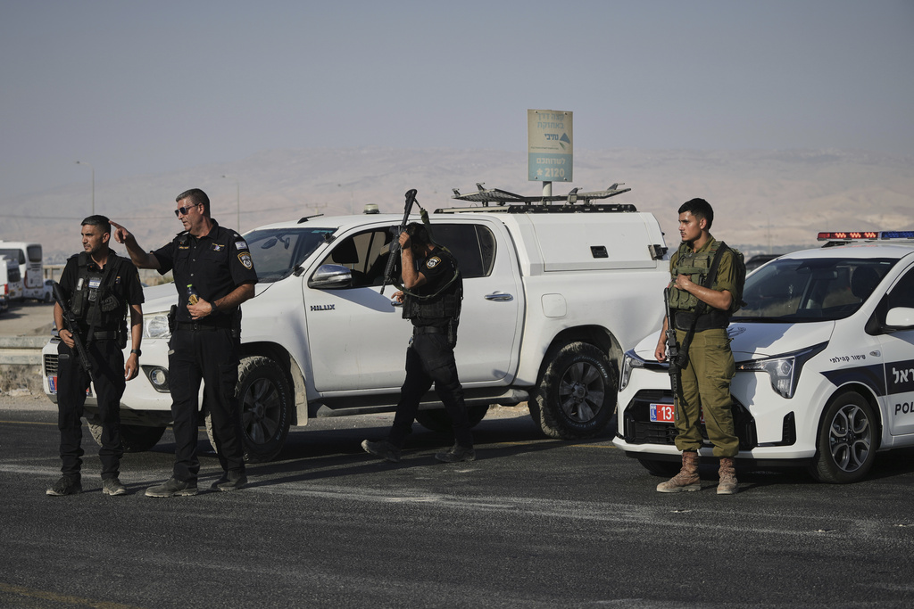 Israeli police and soldiers stand guard near the site of a shooting attack where Israeli officials say two people were shot and killed in a militant attack at the Allenby Bridge Crossing between the West Bank and Jordan, Thursday, Sept. 18, 2025. (AP Photo/Mahmoud Illean)