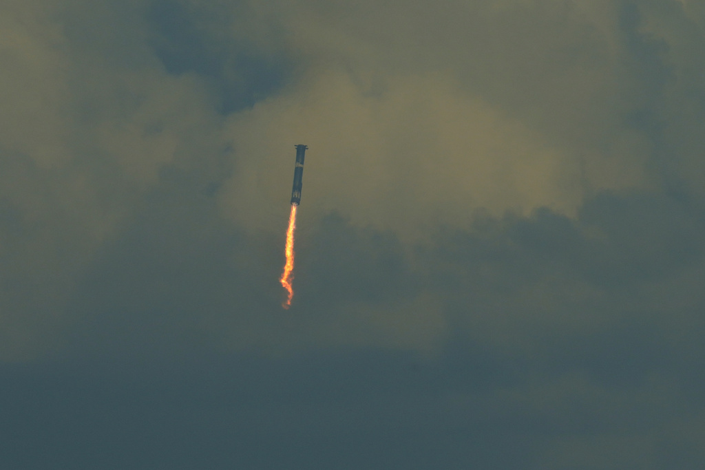 SpaceX's mega rocket booster returns to the gulf during a test flight from Starbase, Texas, Monday, Oct. 13, 2025. (AP Photo/Eric Gay)