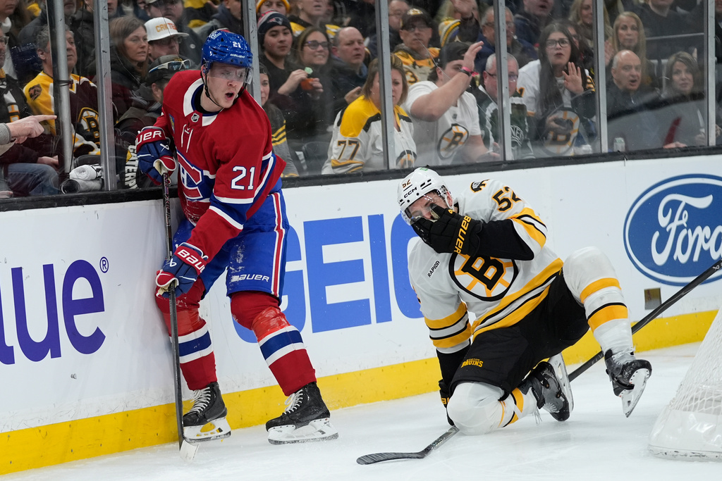 Boston Bruins center Sean Kuraly (52) covers his face after sustaining an injury battling Montreal Canadiens defenseman Kaiden Guhle (21) during the second period of an NHL hockey game against the Boston Bruins in Boston, Saturday, Jan. 24, 2026. (AP Photo/Robert F. Bukaty)