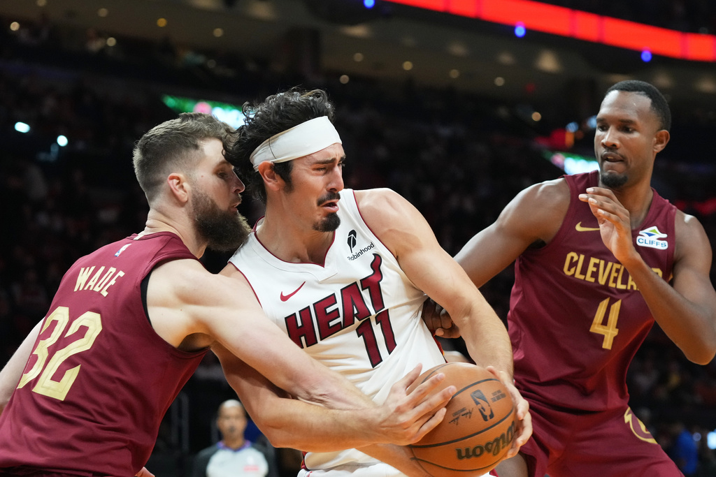 Miami Heat forward Jaime Jaquez Jr. (11) and Cleveland Cavaliers forward Dean Wade (32) go after a rebound during the first half of an NBA basketball game Monday, Nov. 10, 2025, in Miami. (AP Photo/Marta Lavandier)