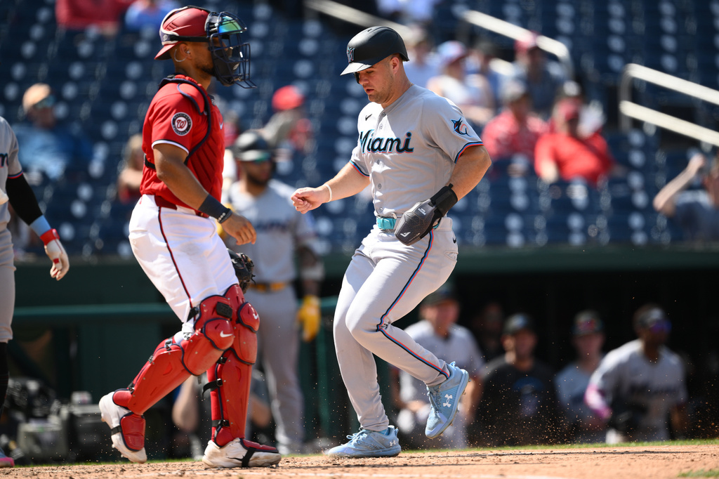 Miami Marlins' Jakob Marsee, right, steals home against Washington Nationals catcher Harry Ford, left, during the ninth inning of a baseball game, Sunday, Aug. 30, 2026, in Washington. (AP Photo/Nick Wass)