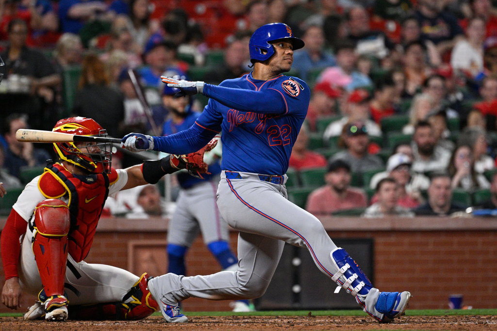 New York Mets' Juan Soto (22) watches his double next to St. Louis Cardinals catcher Ivan Herrera in the sixth inning of a baseball game, Tuesday, March 31, 2026, in St. Louis. (AP Photo/Joe Puetz)