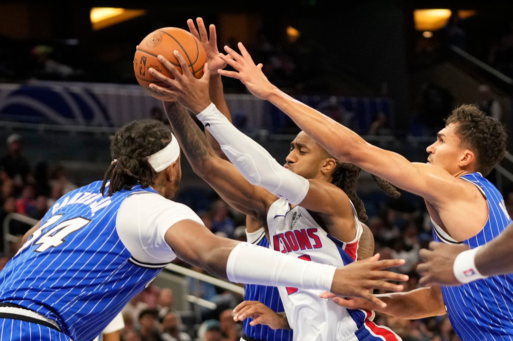 Detroit Pistons guard Daniss Jenkins, center, goes to the basket between Orlando Magic center Wendell Carter Jr., left, and forward Tristan da Silva during the first half of an NBA basketball game, Monday, April 6, 2026, in Orlando, Fla. (AP Photo/John Raoux)