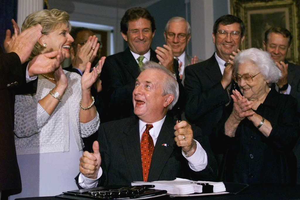 FILE - North Carolina Gov. Jim Hunt, center, gives the thumbs up to House and Senate leadership after signing the 1999-2001 state budget during a ceremony at the Capitol building, in Raleigh, N.C., June 30, 1999. (AP Photo/Chuck Burton, File)