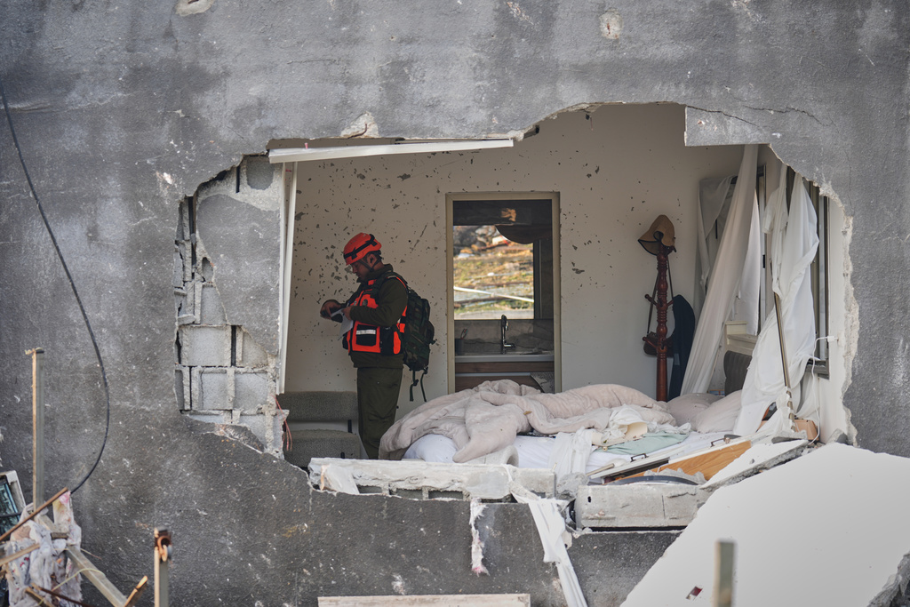Officers from Israel's Home Front Command inspect a house destroyed by an Iranian missile strike in Zarzir, northern Israel, Friday, March 13, 2026. (AP Photo/Ariel Schalit)