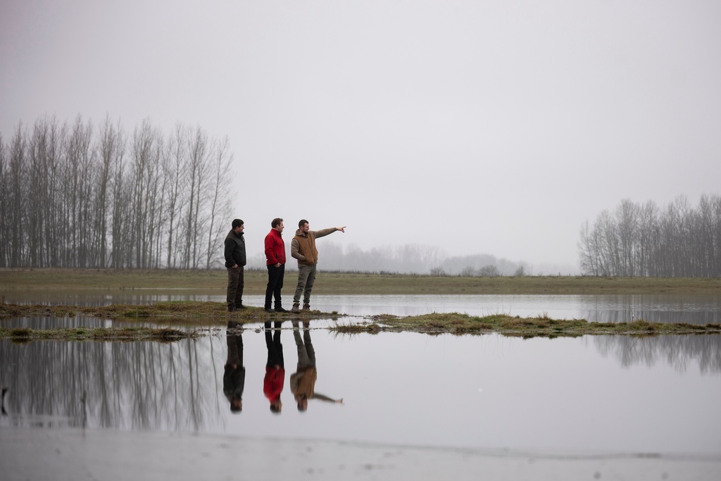 Members of the water guardians group talk next to an artificial lake in Kiskunmajsa, Hungary, Friday, Dec. 12, 2025. (AP Photo/Denes Erdos)