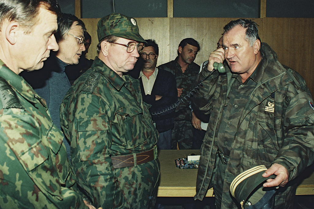 FILE - Bosnian Serb General Ratko Mladic, right, talks on the phone next to Russian Army General Vladimir Zurbenko, center, during the visit of a Russian Army delegation to the Bosnian town of Banja Luka in Oct. 1995. (AP Photo/Radivoje Pavicic, File)