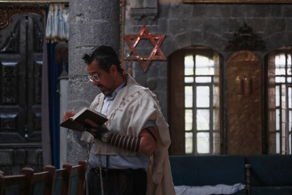Henry Hamra, a Syrian-American Jew who is one of the founders of a new Jewish heritage initiative, reads the Torah, the Jewish holy book, at al-Firenj Synagogue in the old city of Damascus, Syria, Wednesday, Dec. 10, 2025.(AP Photo/Omar Sanadiki)
