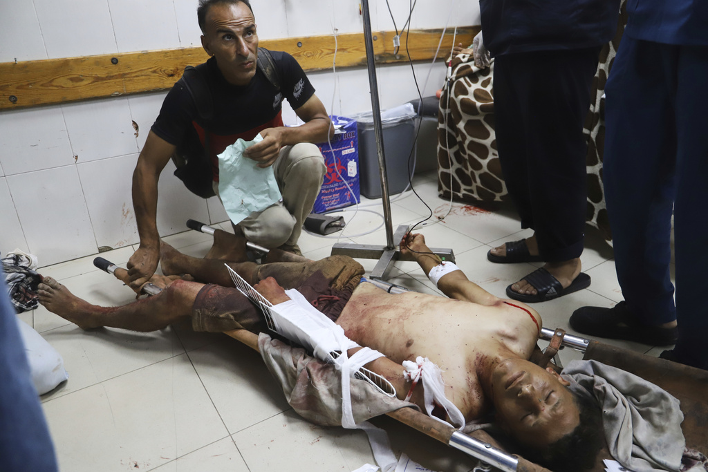 A Palestinian man who was injured at an aid distribution center run by the Gaza Humanitarian Foundation, a U.S.-backed organization approved by Israel, receives treatment on the floor of Nasser Hospital in Khan Younis, southern Gaza Strip, Saturday, July 19, 2025. (AP Photo/Mariam Dagga)
