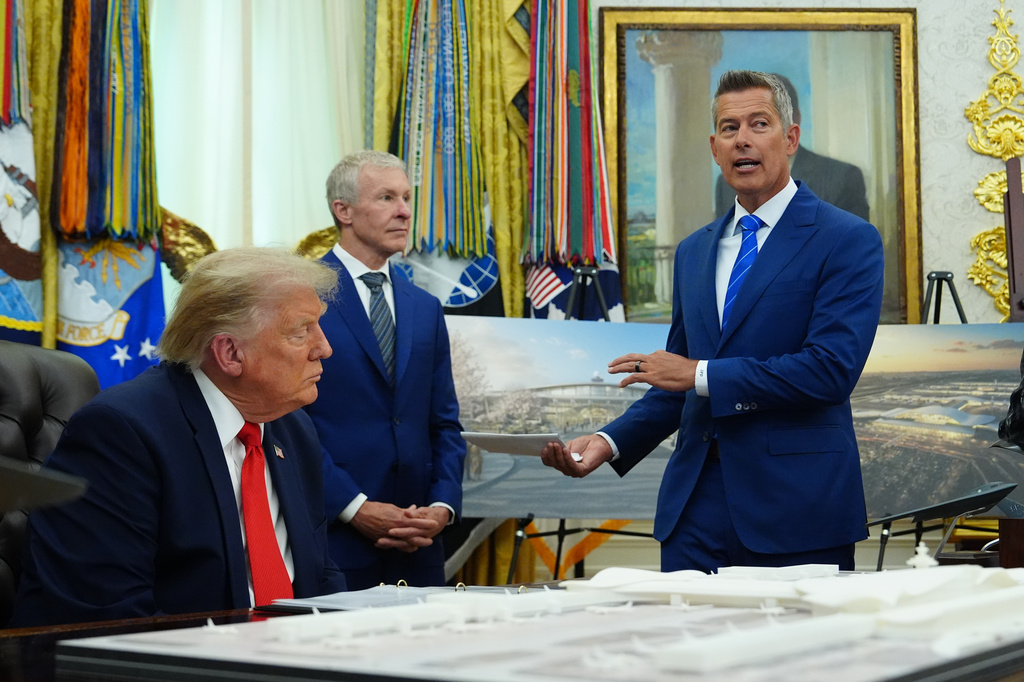 President Donald Trump and Scott Kirby, CEO of United Airlines, listen as Transportation Secretary Sean Duffy speaks in the Oval Office of the White House about Dulles International Airport modernization, Wednesday, July 29, 2026, in Washington. (AP Photo/Julia Demaree Nikhinson)