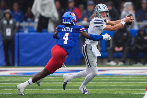 Kansas State quarterback Avery Johnson (2) is chased by Kansas linebacker Trey Lathan (4) during the first half of an NCAA college football game Saturday, Oct. 25, 2025, in Lawrence, Kan. (AP Photo/Charlie Riedel) Kansas State quarterback Avery Johnson (2) is chased by Kansas linebacker Trey Lathan (4) during the first half of an NCAA college football game Saturday, Oct. 25, 2025, in Lawrence, Kan. (AP Photo/Charlie Riedel)