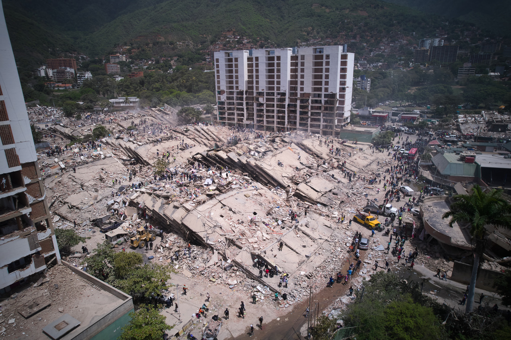 Residents and rescue workers search through the rubble two days after an earthquake struck La Guaira, Venezuela, Friday, June 26, 2026. (AP Photo/Juan Pablo Arraez)