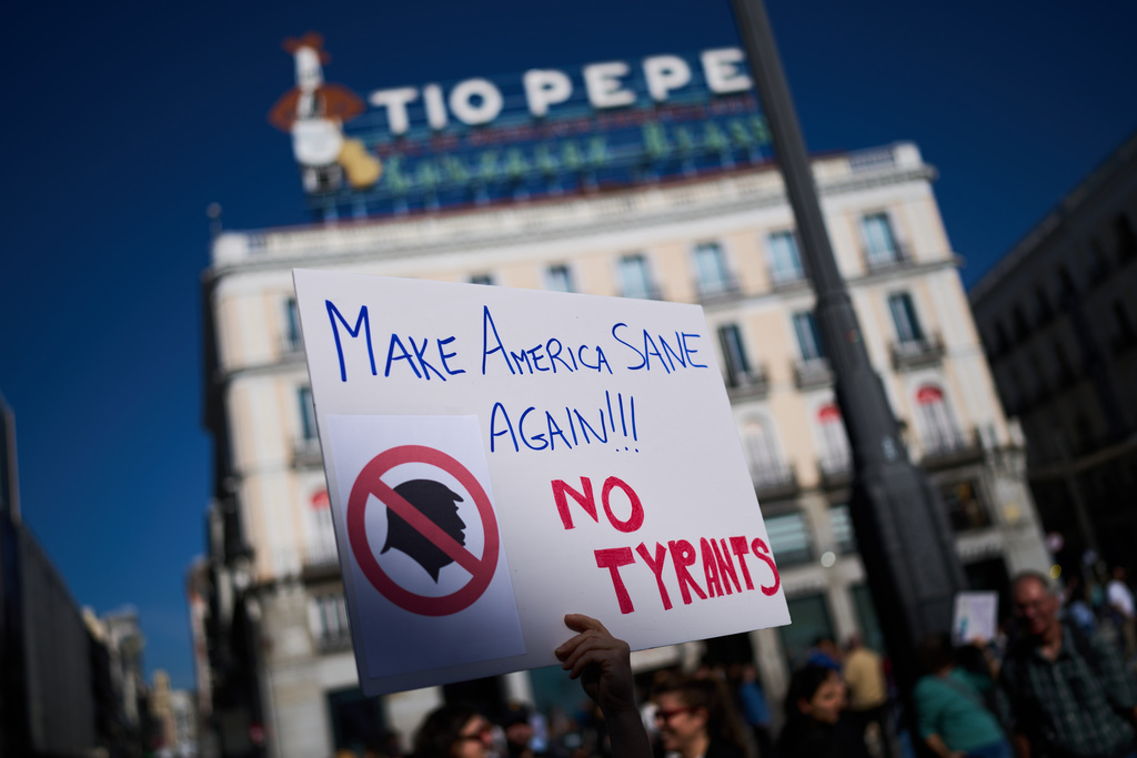 A demonstrator holds a sign during an anti-Trump protest, in Madrid, Spain, Saturday, Oct. 18, 2025. (AP Photo/Bernat Armangue)
