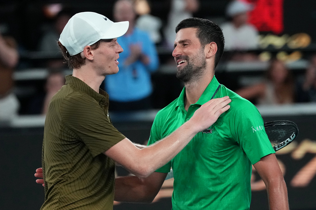 Novak Djokovic, right, of Serbia is congratulated by Jannik Sinner, left, of Italy following their semifinal match at the Australian Open tennis championship in Melbourne, Australia, early Saturday, Jan. 31, 2026. (AP Photo/Aaron Favila)