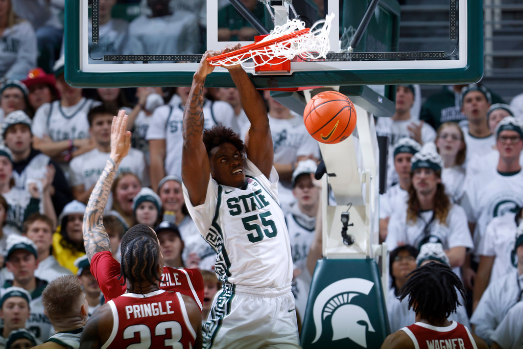 Michigan State forward Coen Carr (55) dunks against Arkansas forward Nick Pringle (23) during the first half of an NCAA college basketball game, Saturday, Nov. 8, 2025, in East Lansing, Mich. (AP Photo/Al Goldis)