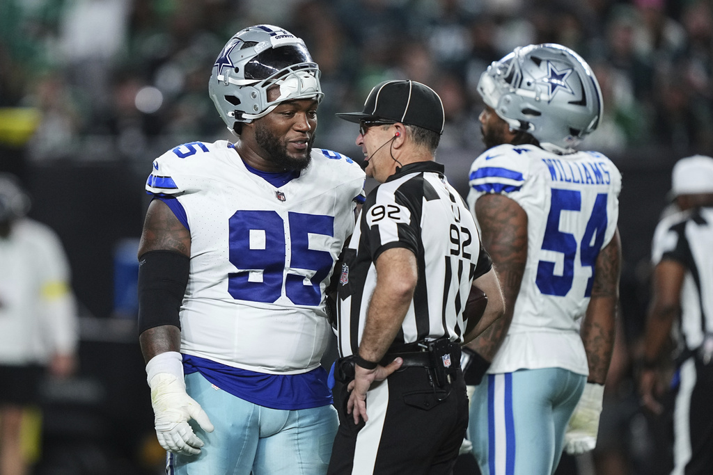 Dallas Cowboys defensive tackle Kenny Clark (95) talks with umpire Bryan Neale (92) in the second half of an NFL football game Thursday, Sept. 4, 2025, in Philadelphia. (AP Photo/Matt Rourke)