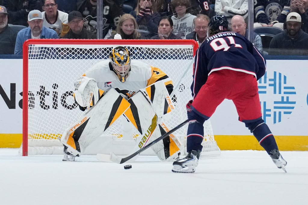 Columbus Blue Jackets center Kent Johnson (91) scores on Pittsburgh Penguins goaltender Sergei Murashov (1) in a shootout in an NHL hockey game in Columbus, Ohio, Friday, Oct. 9, 2026. (AP Photo/Sue Ogrocki)