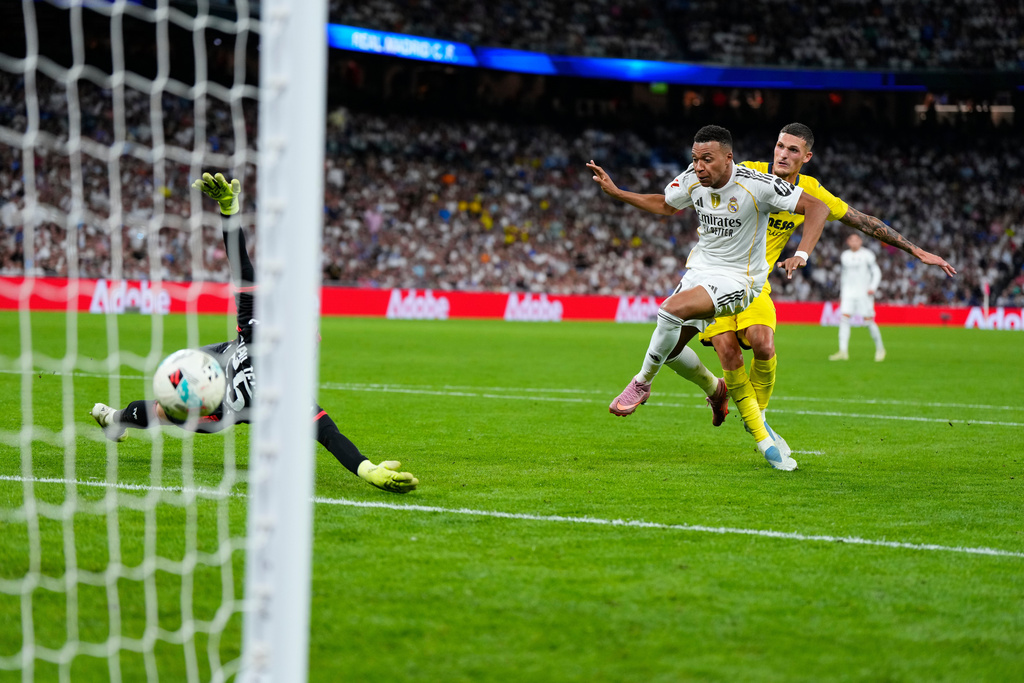 Real Madrid's Kylian Mbappe, centre, scores his side's third goal during the Spanish La Liga soccer match between Real Madrid and Villarreal at the Santiago Bernabeu stadium in Madrid, Spain, Saturday, Oct. 4, 2025. (AP Photo/Manu Fernandez)