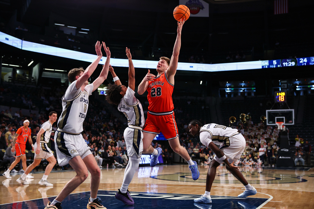 Virginia forward Thijs de Ridder (28) shoots against Georgia Tech center Cole Kirouac, left, guard Eric Chatfield Jr., center, and forward Baye Ndongo, right, during the first half of an NCAA college basketball game, Wednesday, Feb. 18, 2026, in Atlanta. (AP Photo/Colin Hubbard)