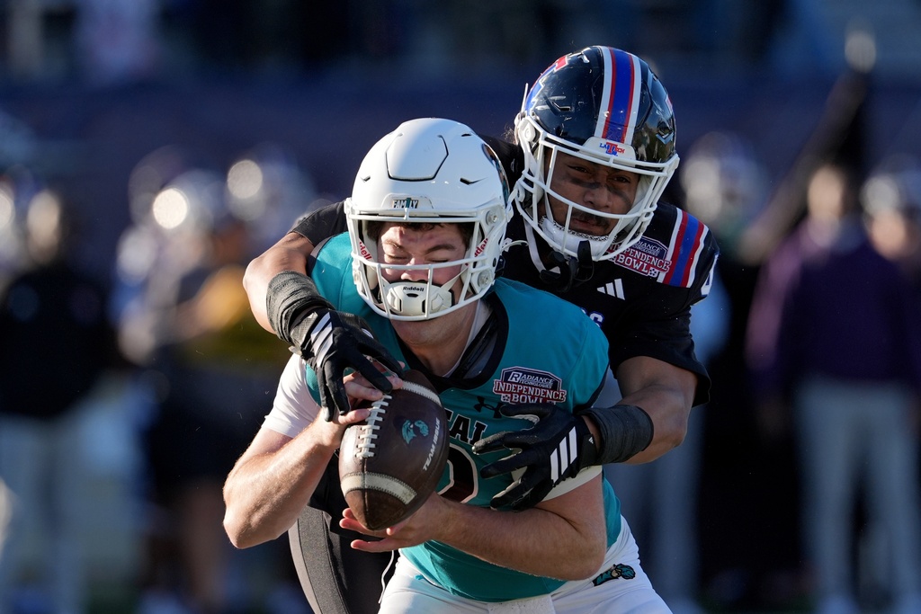 Coastal Carolina quarterback Tad Hudson (12) is sacked by Louisiana Tech linebacker Sifa Leota (42) during the second half of the Independence Bowl NCAA college football game, Tuesday, Dec. 30, 2025, in Shreveport, La. (AP Photo/Rogelio V. Solis)