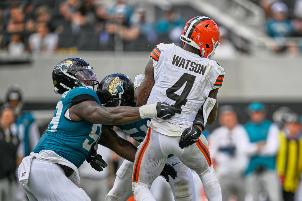 Cleveland Browns quarterback Deshaun Watson (4) is sacked by Jacksonville Jaguars linebacker Jack Kiser, center, and defensive tackle Ruke Orhorhoro, left, in the second half of an NFL football game, Sunday, Sept. 13, 2026, in Jacksonville. (AP Photo/Phelan M. Ebenhack)