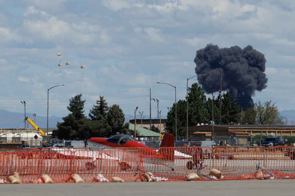 Crew members parachute to the ground, left, following a collision between two U.S. Navy planes during an air show at the Mountain Home Air Force Base, Sunday, May 17, 2026, near Mountain Home, Idaho. (Henk Zuurbier via AP)