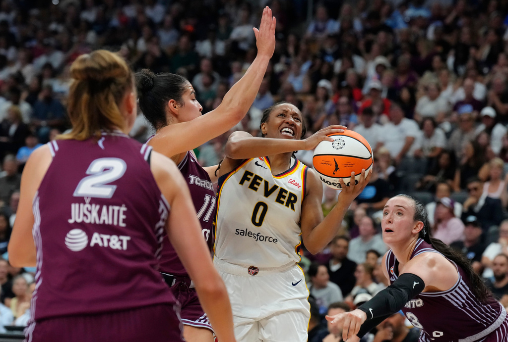 Indiana Fever's Kelsey Mitchell (0) drives as Toronto Tempo's Kia Nurse (11) and Marina Mabrey (3) defend during the first half of a WNBA basketball game in Toronto on Tuesday, Aug. 18, 2026. (Chris Young/The Canadian Press via AP)