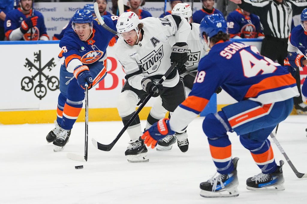 New York Islanders' Logan Stanley (8) fights for control of the puck with -Los Angeles Kings' Artemi Panarin (10) during the first period of an NHL hockey game Thursday, Oct. 22, 2026, in Elmont, N.Y. (AP Photo/Frank Franklin II)