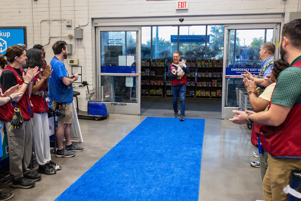 In this photo provided by Lowe's, employees welcome back Francine, the store cat, after she disappeared unexpectedly in September, at the Richmond, Va., Lowe's, Tuesday, Oct. 7, 2025. (Kevin Ridley/Lowe's via AP)
