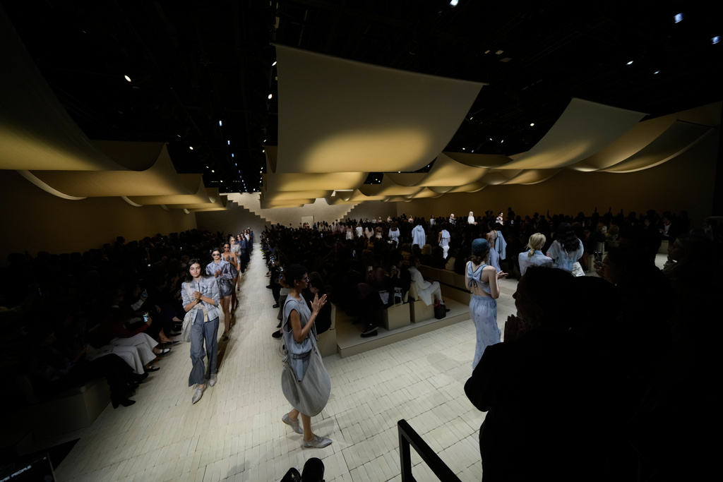 Models claps their hands as they wear creations part of the Emporio Armani women's Spring-Summer 2026 collection, presented in Milan, Italy, Thursday, Sept. 25, 2025. (AP Photo/Luca Bruno)