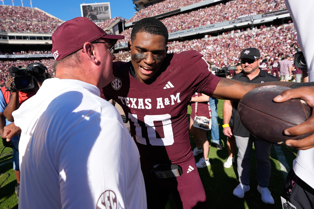 Texas A&M quarterback Marcel Reed (10) celebrates with head coach Mike Elko after an NCAA college football game against South Carolina Saturday, Nov. 15, 2025, in College Station, Texas. (AP Photo/David J. Phillip)