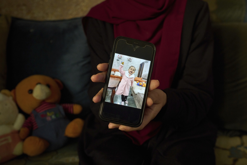 Tayma Asous, 26, shows a photo of her 2-year-old daughter, Layla Al-Khatib, who was killed on Jan. 25, 2025, after being shot in the head by Israeli fire, at their home in the village of Muthallath ash-Shuhada near the West Bank city of Jenin, March 11. (AP Photo/Leo Correa)