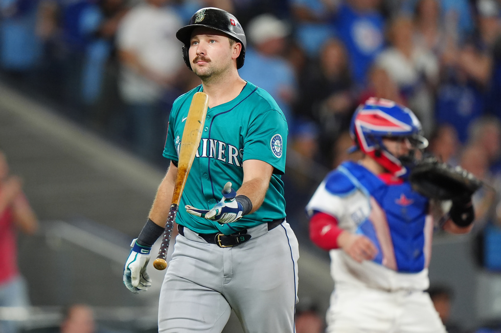 Seattle Mariners' Cal Raleigh, left, reacts after striking out against the Toronto Blue Jays during the sixth inning in Game 6 of baseball's American League Championship Series in Toronto, Sunday, Oct. 19, 2025. (Frank Gunn/The Canadian Press via AP)
