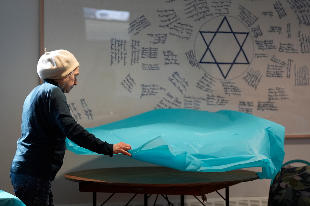Volunteer Marlene Ring spreads a table cloth while preparing a room for a passover meal Monday, March 30, 2026, at the Beth Israel Synagogue in Waterville, Maine. (AP Photo/Robert F. Bukaty)