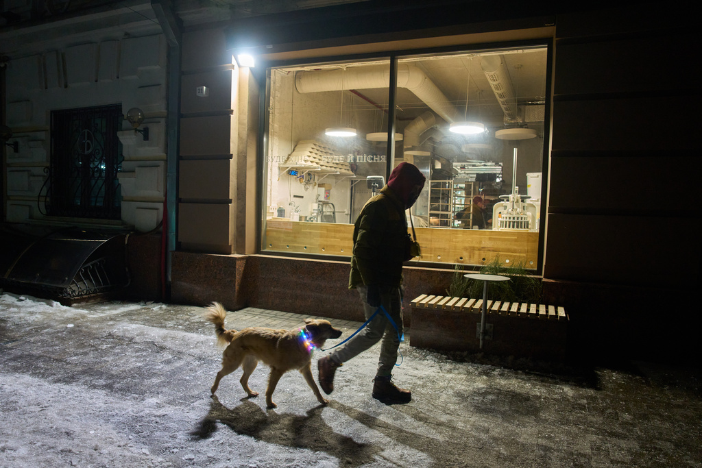 A man passes by a bakery in the early hours Friday, Jan. 30, 2026, in Kyiv. (AP Photo/Efrem Lukatsky)
