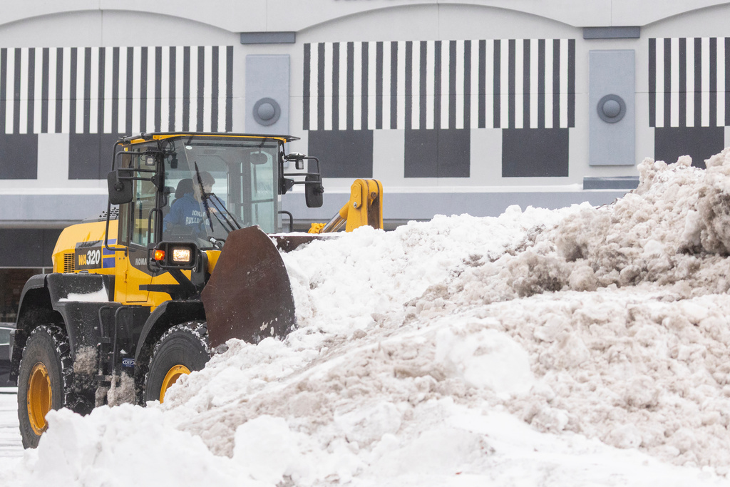 Snow is cleared from a parking lot in Grandville, Mich. on Monday Dec. 29, 2025. (Joel Bissell /MLive.com via AP)