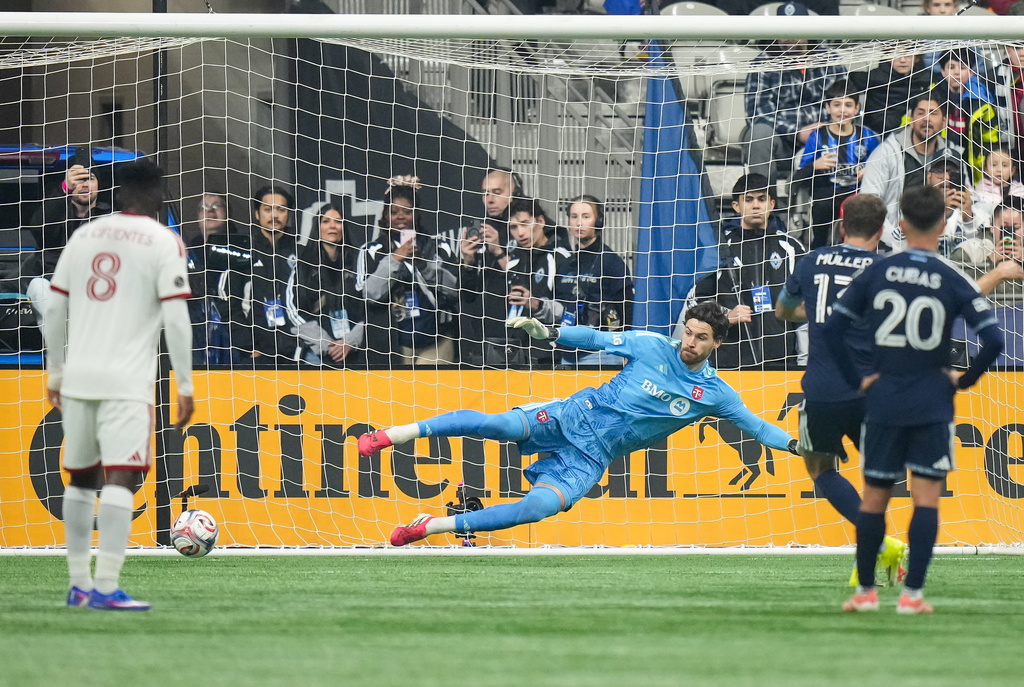 Toronto FC goalkeeper Luka Gavran allows a goal to Vancouver Whitecaps' Thomas Muller, back right, on a penalty kick during the first half of an MLS soccer match, in Vancouver, on Saturday, Feb. 28, 2026. (Darryl Dyck/The Canadian Press via AP)
