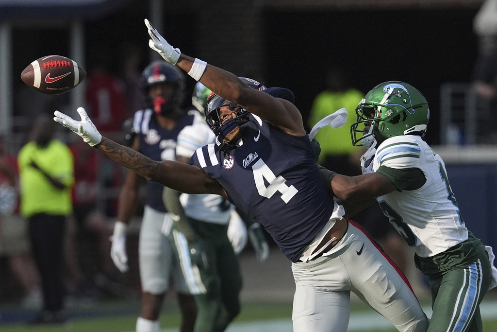 Mississippi wide receiver Caleb Odom (4) reaches for an over thrown pass while covered by Tulane safety Tavare Smith (13) during the second half of an NCAA college football game in Oxford, Miss., Saturday, Sept. 20, 2025. (AP Photo/Rogelio V. Solis)
