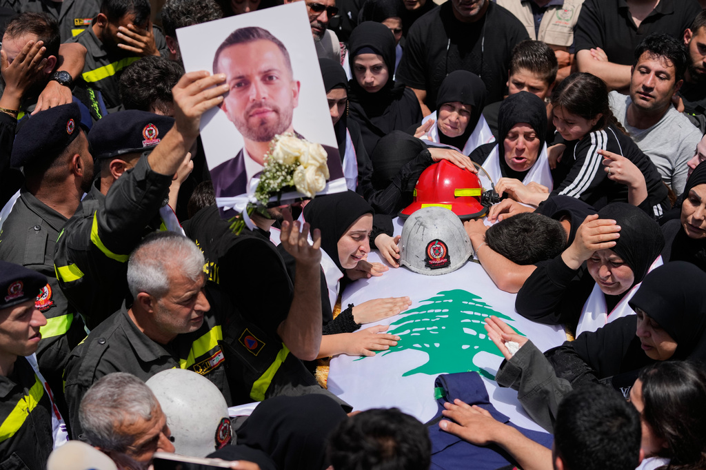 Mourners react over the coffin of Lebanese Civil Defense member, Hussein Jaber, who was killed on Tuesday in an Israeli airstrike during a funeral procession in the coastal city of Sidon, Lebanon, Wednesday, May 13, 2026. (AP Photo/Mohammed Zaatari)
