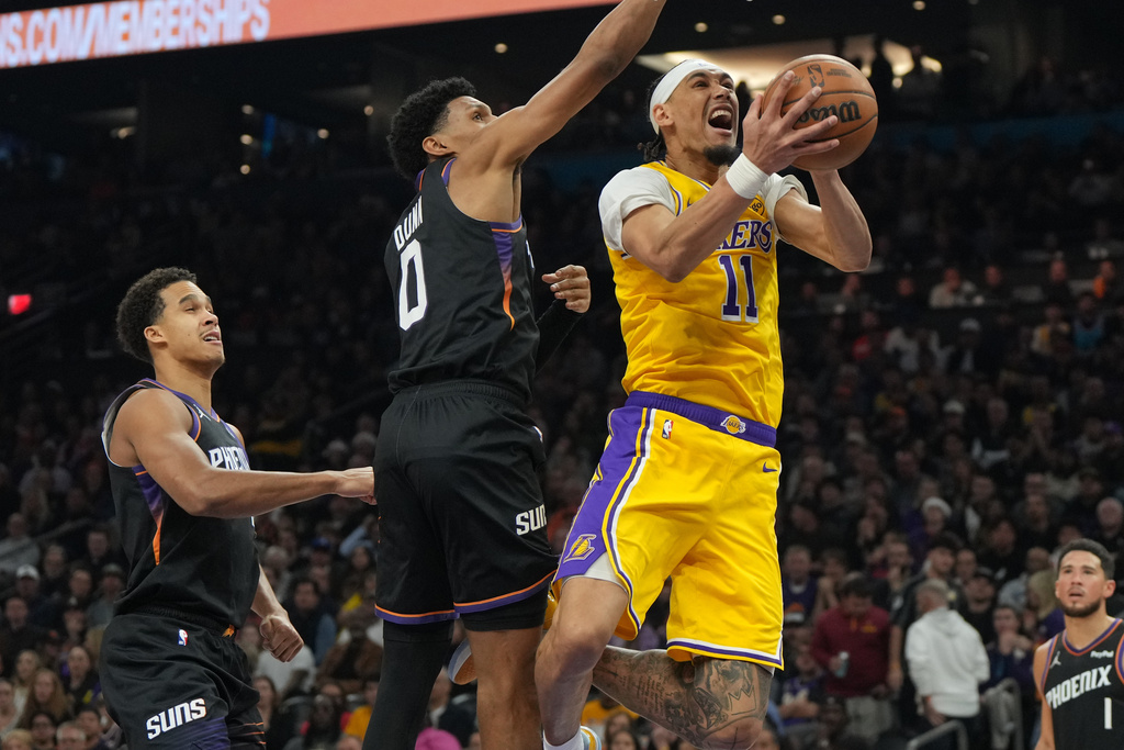 Los Angeles Lakers center Jaxson Hayes (11) gets fouled by Phoenix Suns forward Ryan Dunn (0) during the first half of an NBA basketball game, Tuesday, Dec. 23, 2025, in Phoenix. (AP Photo/Rick Scuteri)