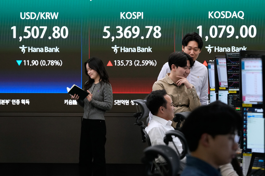 Currency traders work near a screen showing the Korea Composite Stock Price Index (KOSPI), top center, and the foreign exchange rate between U.S. dollar and South Korean won, top center left, at the foreign exchange dealing room of the Hana Bank headquarters in Seoul, South Korea, Friday, April 3, 2026. (AP Photo/Ahn Young-joon)